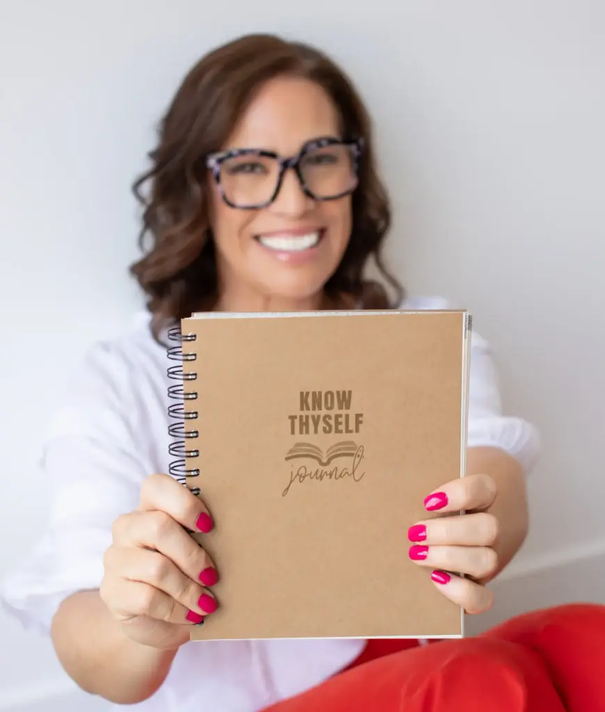 Halle Simpson holding the Know Thyself Journal, a self-reflection resource for leadership growth and self-awareness.